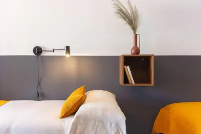 a bedroom with a white bed with a yellow pillow at Duplex with terrace near Bcn in Terrassa