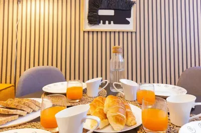 a table with plates of croissants and glasses of orange juice at Duplex with terrace near Bcn in Terrassa