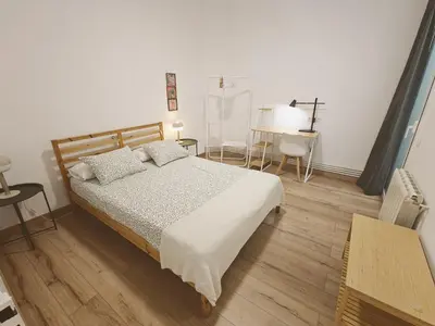 a bedroom with a bed and a desk and a table at Apartamento nuevo en Terrassa Centro in Terrassa