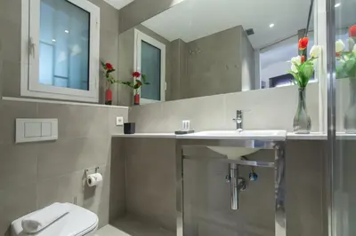 a bathroom with a sink and a toilet and a mirror at Housalia Sant Pau Views- Suite with View on Hospital Sant Pau in Barcelona
