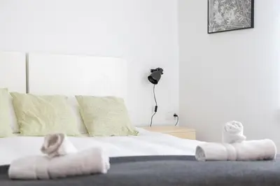 a bedroom with a bed with towels on it at Housalia Lepant 3 bedroom apartment 300 meters de Sagrada Familia in Barcelona