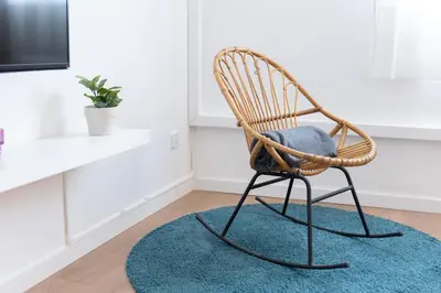 a wicker chair sitting on a rug in a room at Housalia Lepant 3 bedroom apartment 300 meters de Sagrada Familia in Barcelona