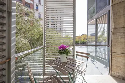 a balcony with a table with flowers on it at Marion House Barcelona in Barcelona