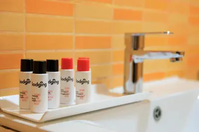 a bathroom sink with several bottles of lip gloss at Housalia Corsega - Apartment 3 bedrooms next to Sagrada Familia in Barcelona