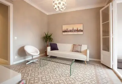 a living room with a white couch and a chandelier at Enjoy Apartments Sofia in Barcelona
