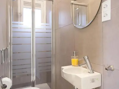 a bathroom with a sink and a shower with a mirror at Enjoy Apartments Sofia in Barcelona