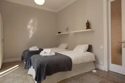 two beds in a room with white walls at Enjoy Apartments Sofia in Barcelona