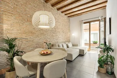 a living room with a table and a brick wall at Ola Living MACBA in Barcelona