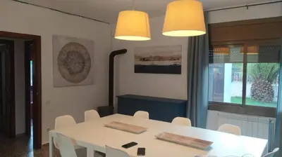a dining room with a white table and white chairs at Villa Franz House Casa Principal in Canyelles