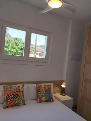 a bedroom with a bed with two pillows and a window at Villa Franz House Casa de Invitados in Canyelles