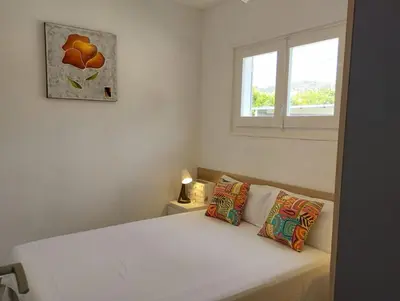 a bedroom with a white bed with a window at Villa Franz House Casa de Invitados in Canyelles