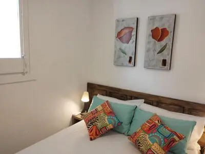 a bedroom with a bed with three paintings on the wall at Villa Franz House Casa de Invitados in Canyelles