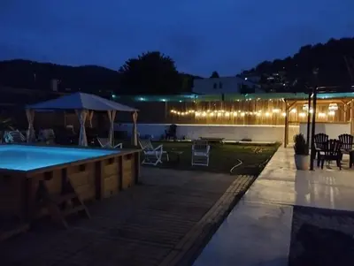 a swimming pool at night with lights on a building at Villa Franz House Casa de Invitados in Canyelles