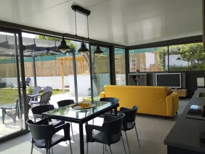 a living room with a yellow couch and a table at Villa Franz House Casa de Invitados in Canyelles