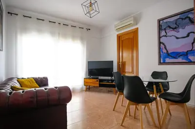a living room with a couch and a table and chairs at Apartamento al lado Del Mar in Sant Adria de Besos