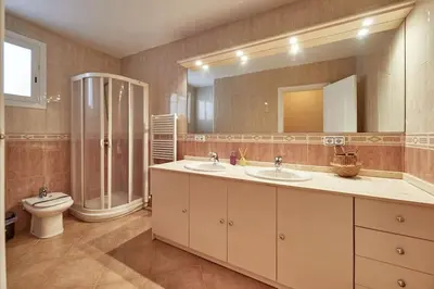 a bathroom with two sinks and a shower and a toilet at Villa lluna en Olivella, Sitges, Barcelona in Olivella