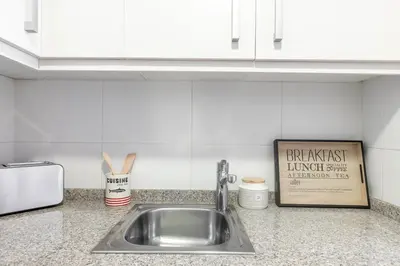 a kitchen counter with a sink and a sign at The Orbit Apartments in Barcelona