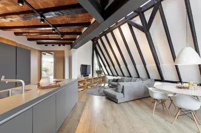 a kitchen and living room with a couch and a table at Enjoy Apartments La Riera Penthouse in Barcelona