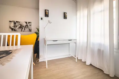 a room with a white desk and a table at Central & Fully Equipped Apartment in Eixample Next to Metro, Sleeps 5 in Barcelona