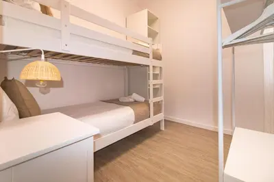 a small bedroom with bunk beds and a desk at Central & Fully Equipped Apartment in Eixample Next to Metro, Sleeps 5 in Barcelona