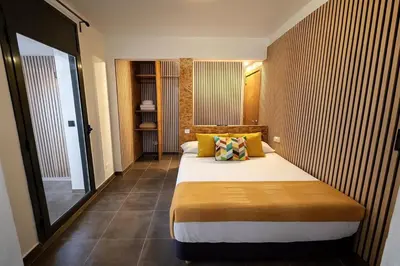 a bedroom with a large bed with yellow pillows at MT Boutique Suites y Apartamentos - Adults Only - in Mataró