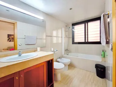 a bathroom with a sink and a toilet and a tub at Duplex con piscina en Rubí in Rubí