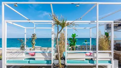 a white canopy bed with the ocean in the background at HomeHolidaysRentals Deva - Costa Barcelona in Pineda de Mar