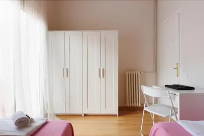 a bedroom with a bed and a desk and a white cabinet at Elegance and Comfort in Barcelona, 4Bedroom Apartment in the Most Exclusive Area in Barcelona