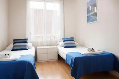 two beds in a room with blue and white at Elegance and Comfort in Barcelona, 4Bedroom Apartment in the Most Exclusive Area in Barcelona
