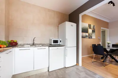 a kitchen with white cabinets and a white refrigerator at Elegance and Comfort in Barcelona, 4Bedroom Apartment in the Most Exclusive Area in Barcelona