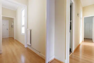 an empty hallway with white walls and a wooden floor at Elegance and Comfort in Barcelona, 4Bedroom Apartment in the Most Exclusive Area in Barcelona