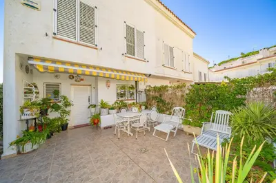 a patio with a table and chairs in front of a building at HomeHolidaysRentals Ancora - Costa Barcelona in San Pol de Mar