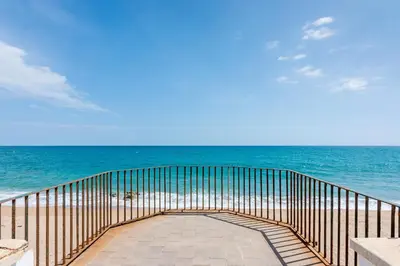 a walkway to the beach with the ocean in the background at HomeHolidaysRentals Ancora - Costa Barcelona in San Pol de Mar