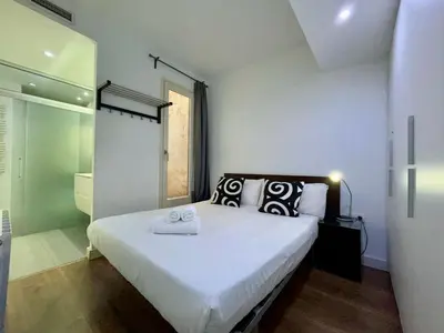 a bedroom with a large white bed with towels on it at BarcelonaForRent Tucson Suites in Barcelona