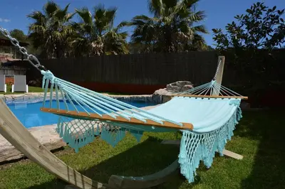 a hammock in a yard next to a pool at Villa Sitges El Olivo High Comodity AC Pool Heated 30º Optional Real Garden Pool XXL 10 min drive from Sitges in Olivella