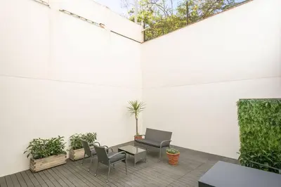 a patio with chairs and a table and plants at Alcam Galileu in Barcelona
