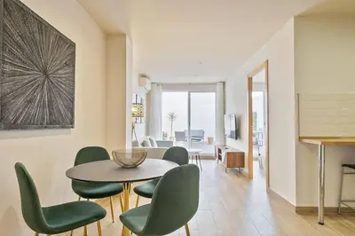 a dining room with a table and green chairs at Alcam Galileu in Barcelona