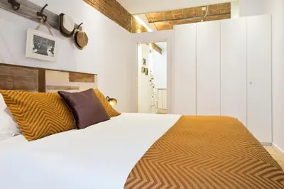 a bedroom with a large white bed with brown pillows at Charming Parallel in Barcelona
