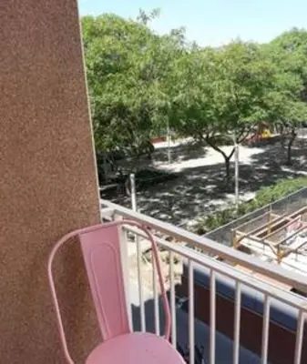a balcony with a pink chair on a building at Designer Apt near FIRA Balcony 5PPWIFISMART TV by MyRentalHost in Hospitalet de Llobregat