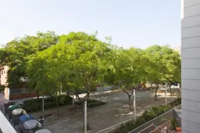 a view of a park with trees and a building at Designer Apt near FIRA Balcony 5PPWIFISMART TV by MyRentalHost in Hospitalet de Llobregat
