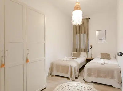 a bedroom with two beds and a chandelier at Great Eixample Apartment in Barcelona