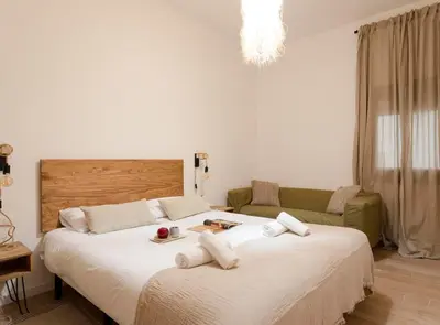 a bedroom with two beds and a couch at Great Eixample Apartment in Barcelona