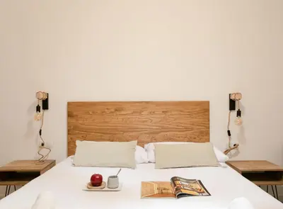 a bedroom with a white bed with a wooden headboard at Great Eixample Apartment in Barcelona