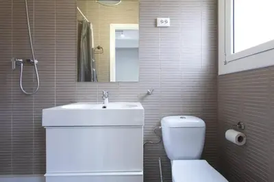 a bathroom with a sink and a toilet and a mirror at Bright & Spacious Family Flat in Central Barcelona in Barcelona
