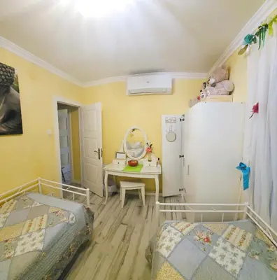 a bedroom with two beds and a table and a refrigerator at Sweet home in Sant Adria de Besos