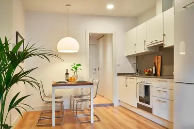 a kitchen with a table and chairs in a room at Catalan Comfort near Sagrada Familia by MyRentalHost in Barcelona