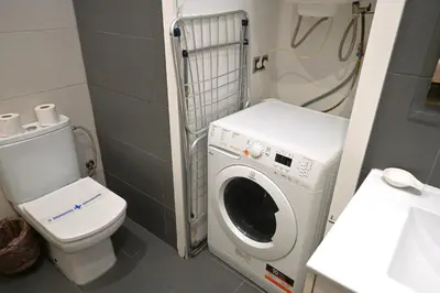 a bathroom with a washing machine and a toilet at Homenfun Barcelona Guinardó Hospital Sant Pau in Barcelona