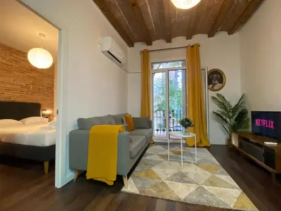 a living room with a couch and a bed at Cosy Urban Oasis 1BD in Poble Sec By MyRentalHost in Barcelona