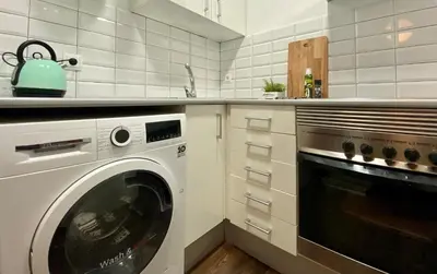 a white kitchen with a washing machine in it at Cosy Urban Oasis 1BD in Poble Sec By MyRentalHost in Barcelona