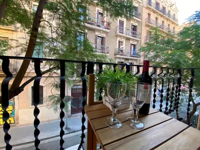 a wooden table with two glasses and a bottle of wine at Cosy Urban Oasis 1BD in Poble Sec By MyRentalHost in Barcelona